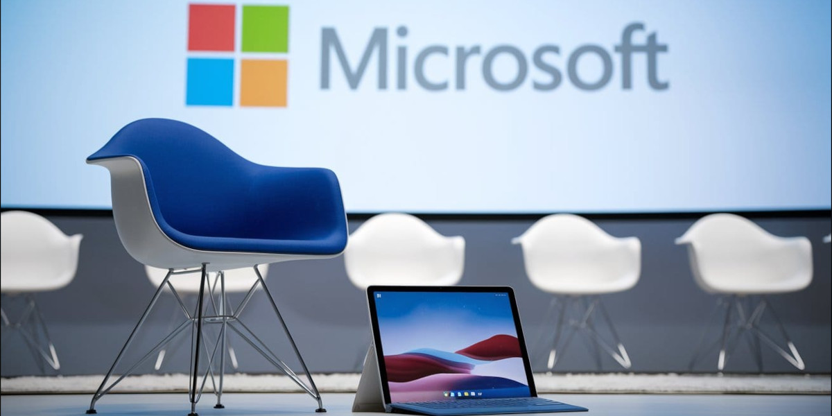Microsoft logo projected on a stage with a laptop in the foreground